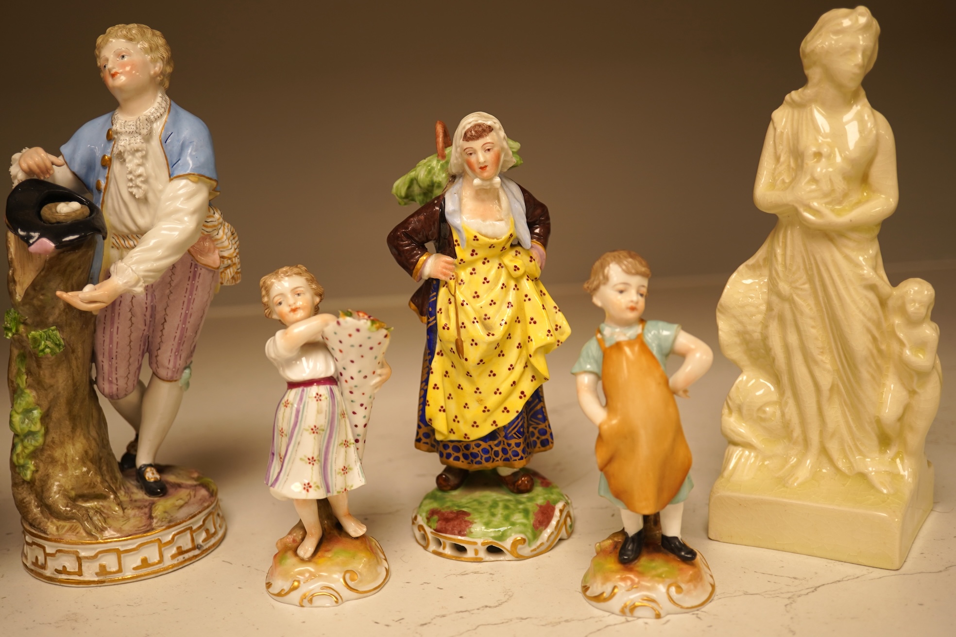 A pair of 19th century Meissen figurines, a Crown Derby figure, a pair of miniature figures and a Leeds type creamware group of Venus and Cupid, tallest 18cm high.